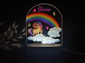 Personalizowana lampka LED z motywem bajkowego jednorożca pod kolorową tęczą wśród chmurek, idealna na prezent dla dziecka lub do stworzenia magicznej atmosfery w pokoju malucha.