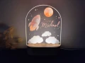 Personalizowana lampka LED z motywem rakiety i chmurek w nocnym niebie, świetna dekoracja do pokoju dziecka lub prezent na urodziny.