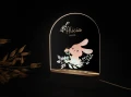 Akrylowa lampka LED dla dzieci przedstawiająca różowego zajączka otoczonego listkami i kwiatami, elegancka dekoracja do pokoju dziecięcego i świetny pomysł na prezent dla noworodka.