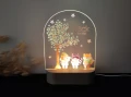 Personalizowana lampka LED dla dzieci ukazująca jesienny krajobraz z drzewem w serduszkowych liściach i trzema ubranymi zwierzątkami, idealna na prezent dla dziecka oraz jako element aranżacji wnętrza w stylu leśnym lub skandynawskim.