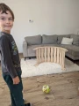 Chłopiec bawi się piłką obok bujaka Montessori 90 cm ustawionego pionowo.