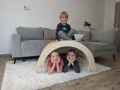 Zabawa dzieci bujakiem Montessori 90 cm ustawionym jako tunel i domek.