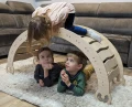 Trójka dzieci bawiąca się na i pod drewnianym bujakiem Montessori 120 cm