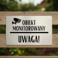 Oznaczenie o monitoringu zamontowane na płocie.