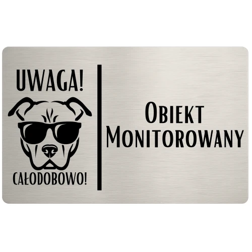 Tabliczka z grafiką psa w okularach i napisem „Obiekt monitorowany”.