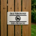 Informacyjna tablica zakazująca parkowania przy bramie wjazdowej.