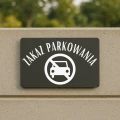 Informacyjna tablica ostrzegająca przed parkowaniem na wjeździe.